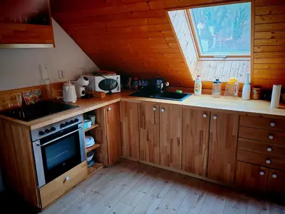 a kitchen with wooden cabinets and a stove and a window at apartmán Sázava in Sázava