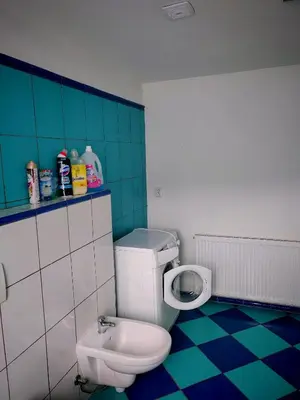 a bathroom with a white toilet and blue tiles at apartmán Sázava in Sázava