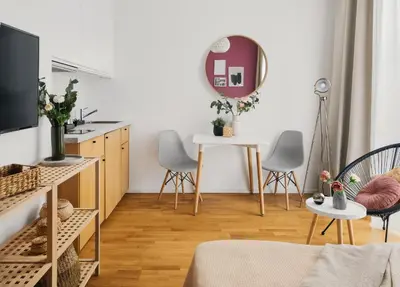 a living room with a table and chairs and a mirror at TurnKey I Downtown Studio in Prague