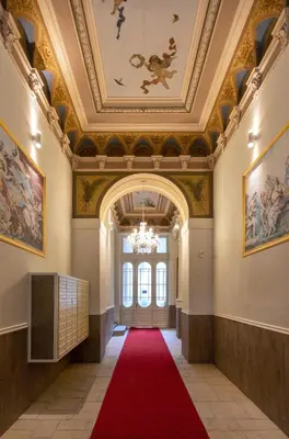an ornate hallway with a red carpet and a ceiling at TurnKey I Downtown Studio in Prague