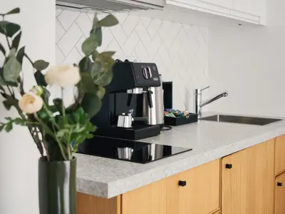 a kitchen counter with a coffee pot and a vase with flowers at TurnKey I Downtown Studio in Prague
