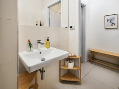 a bathroom with a white sink and a mirror at TurnKey I Downtown Studio in Prague