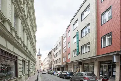 a city street with buildings and cars parked on the street at Riben House Prague in Prague