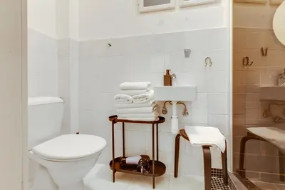 a white bathroom with a toilet and a sink at Riben House Prague in Prague