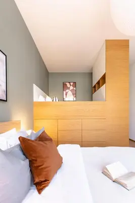 a bedroom with a white bed with a wooden headboard at TurnKey I Main Bus Station Apartments in Prague
