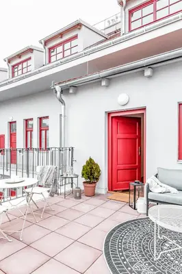 a red door on a white building with a patio at TurnKey I Main Bus Station Apartments in Prague