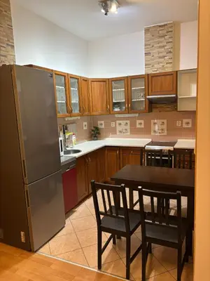 a kitchen with a refrigerator and a table and chairs at Apartmány Topolová 909B in Milovice