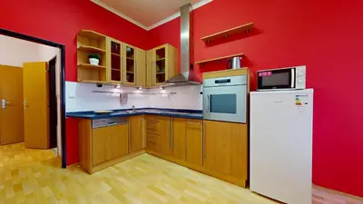 a kitchen with red walls and a white refrigerator at Apartmány Topolová 909B in Milovice
