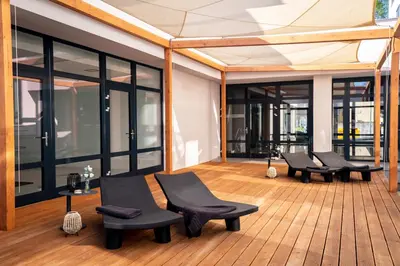 a room with black chairs and windows on a wooden floor at Hotel & Spa Chariclea in Poděbrady
