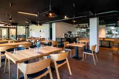a restaurant with wooden tables and chairs and a bar at Hotel & Spa Chariclea in Poděbrady