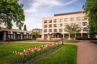 a building with red and white tulips in front of it at Hotel & Spa Chariclea in Poděbrady