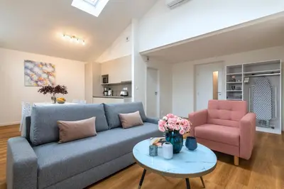 a living room with a blue couch and a pink chair at Hidden Art Boutique Residence by Dwellfort in Prague