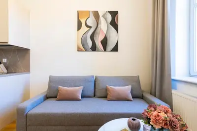 a living room with a blue couch and a table at Hidden Art Boutique Residence by Dwellfort in Prague