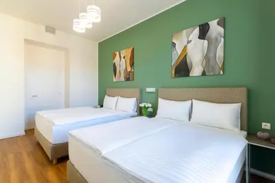 two beds in a room with green walls at Hidden Art Boutique Residence by Dwellfort in Prague