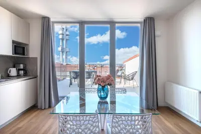 a glass table with a vase of flowers on it at Hidden Art Boutique Residence by Dwellfort in Prague