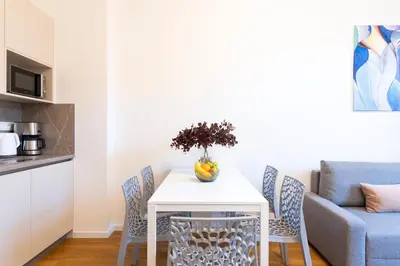 a table with chairs and a vase of flowers on it at Hidden Art Boutique Residence by Dwellfort in Prague
