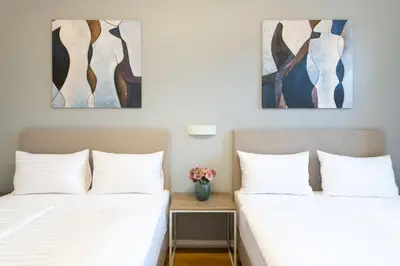 two beds in a room with paintings on the wall at Hidden Art Boutique Residence by Dwellfort in Prague