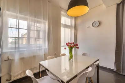 a dining room with a vase of flowers on a table at Štupartská - Tyn Church View Residence with terrace in Prague