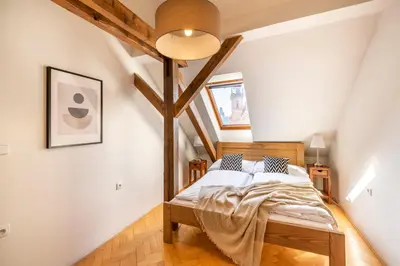 a bedroom with a bed in a attic at Štupartská - Tyn Church View Residence with terrace in Prague