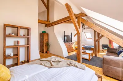 a bedroom with a bed and a living room at Štupartská - Tyn Church View Residence with terrace in Prague