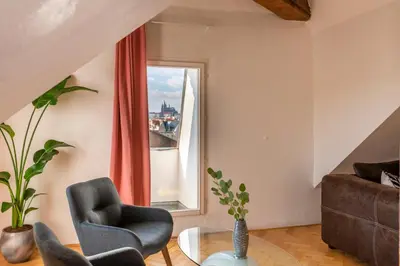 a living room with a couch and a window at Štupartská - Tyn Church View Residence with terrace in Prague