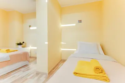 a bedroom with two beds and yellow towels at Jane's Charming Apartment in Prague