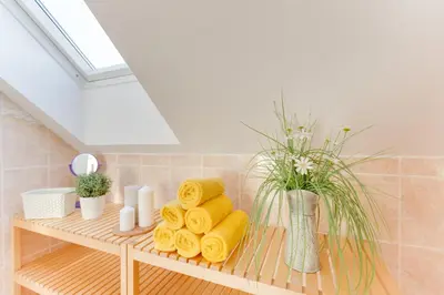 a bathroom with a shelf with towels and a window at Jane's Charming Apartment in Prague