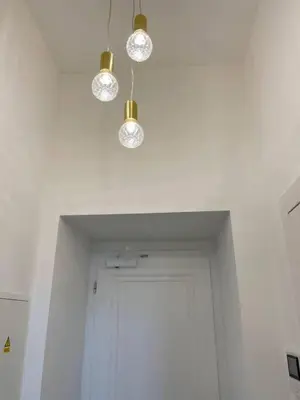 a hallway with a door and three lights on the ceiling at 2-Bed Apartment in Praha in Hřebečníky