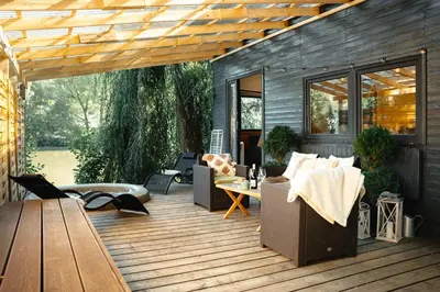 a deck with a couch and chairs on it at Secret Lake Prag magic place relaxation& wellness in Řehenice