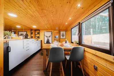 a kitchen with a dining table in a tiny house at Secret Lake Prag magic place relaxation& wellness in Řehenice