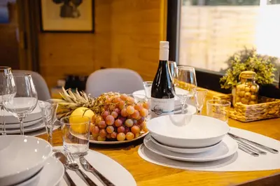 a table with a plate of grapes and a bottle of wine at Secret Lake Prag magic place relaxation& wellness in Řehenice