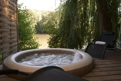 a hot tub with water in it on a deck at Secret Lake Prag magic place relaxation& wellness in Řehenice