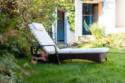 a reclining chair in the grass in front of a house at Oplanská chalupa in Oplany