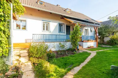 a white house with a blue fence and a yard at Oplanská chalupa in Oplany