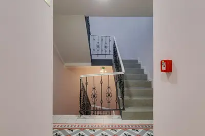 a staircase with a metal railing in a building at Cosy apartment right after the National Museum in Prague