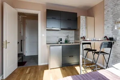 a kitchen with a counter and two chairs in a room at Cosy apartment right after the National Museum in Prague