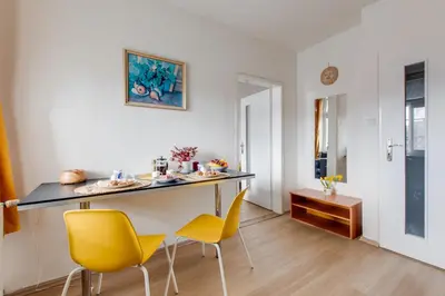 a dining room with a table and yellow chairs at Sunshine Apartment near the City center in Prague