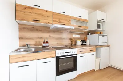 a white bathroom with a sink and a table at Sunshine Apartment near the City center in Prague