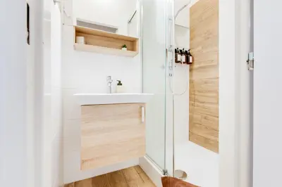 a bathroom with a toilet and a white tiled wall at Sunshine Apartment near the City center in Prague