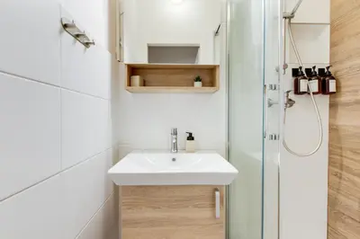 a white bathroom with a toilet and a sink at Sunshine Apartment near the City center in Prague