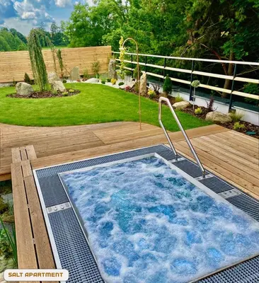 a hot tub on a deck in a yard at You and Me Apartments in Prosenická Lhota