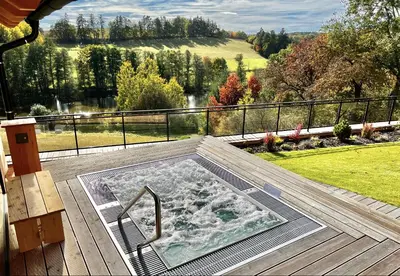 a hot tub on the deck of a house at You and Me Apartments in Prosenická Lhota