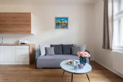 a living room with a couch and a table at Prague Tales Boutique Residence by Dwellfort in Prague