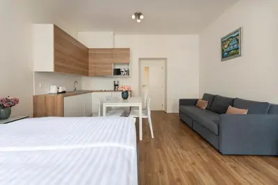 a living room and kitchen with a bed and a couch at Prague Tales Boutique Residence by Dwellfort in Prague