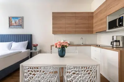 a kitchen and living room with a table and chairs at Prague Tales Boutique Residence by Dwellfort in Prague