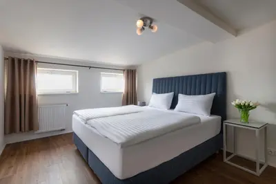 a bedroom with a large white bed with a blue headboard at Prague Tales Boutique Residence by Dwellfort in Prague