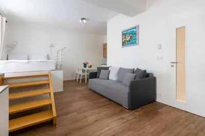 a living room with a couch and a bed at Prague Tales Boutique Residence by Dwellfort in Prague