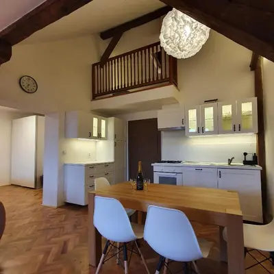 a kitchen with a wooden table and white chairs at Prague Castle View Apartment in Prague