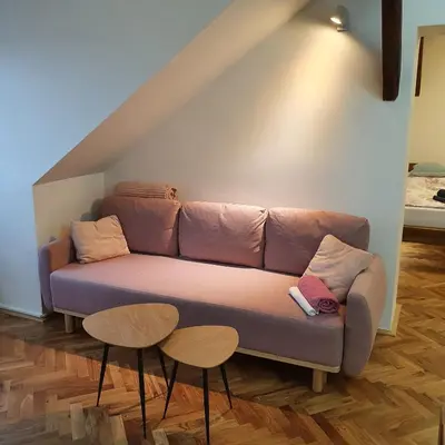 a couch in a living room with two tables at Prague Castle View Apartment in Prague