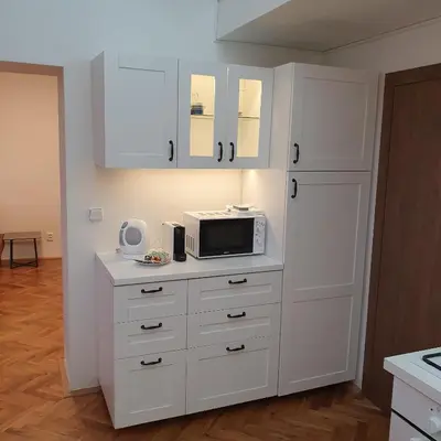a kitchen with white cabinets and a microwave on a counter at Prague Castle View Apartment in Prague